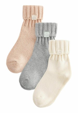 Tre paia di calze in morbido tessuto a maglia; i colori includono rosa chiaro, grigio e crema. Ognuna presenta un polsino a costine e un piccolo etichetta con logo.