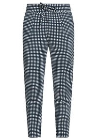 Spodnie w kratę w odcieniach granatu i bieli, z elastycznym paskiem, plisami oraz zwężającym się krojem. Gładka tkanina o lekkiej fakturze.
