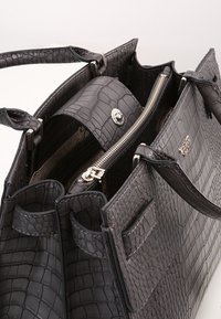 Szara torebka z tłoczonej skóry w wzór krokodyla, z podwójnymi uchwytami, srebrnym okuciem, zamknięciem na zamek błyskawiczny oraz wieloma wewnętrznymi przegródkami do organizacji.