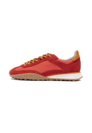 Roter und oranger Sneaker mit niedrigem Schaft, strukturierter Gummisohle, gelb-schwarzen gemusterten Schnürsenkeln und Obermaterial aus Wildleder und Stoff an der Seitenpartie.