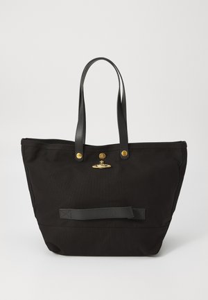 Large black tote bag made of canvas with black leather handles and a gold hardware accent at the center. Features a flat leather strip at the base.