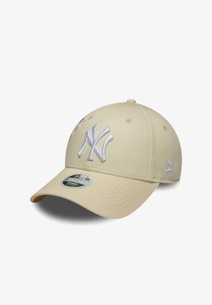 Beige Baseballmütze mit weißem, gesticktem New York Yankees-Logo und gebogenem Schirm, leicht seitlich auf weißem Hintergrund dargestellt.