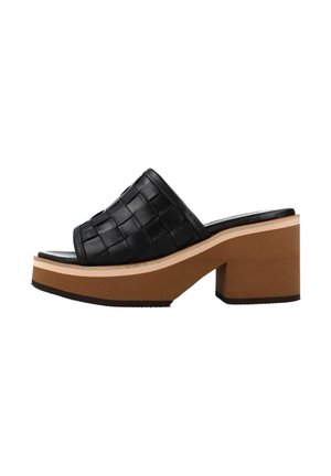 Sandalia tipo slide de cuero negro tejido con una correa ancha, que presenta un tacón plataforma grueso de color marrón claro y suela de goma texturizada.