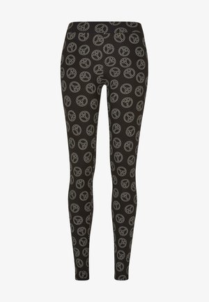 Leggings negros hechos de una tela suave, con un patrón repetido de símbolos de paz en blanco. Diseñados para un ajuste ceñido con una cinturilla elástica.