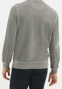Grauer Pullover mit langen Ärmeln, gerippten Bündchen und Saum. Glatte Textur mit Rundhalsausschnitt und dezentem Stitching-Detail auf der Rückseite.