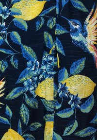 Květinová látka s žlutými citrony, modrými listy a ptáky na tmavě námořnickém pozadí. Textura je hladká s živými, detailními vzory.