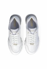 Zapatillas blancas de cuero liso con puntera redonda, diseño de cordones y sutiles acentos dorados en la lengüeta y el lateral. Suela texturizada gris.