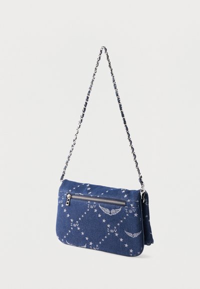 Sac d'épaule en denim bleu avec motifs d'étoiles et d'ailes argentés, poche zippée à l'avant et bandoulière en chaîne argentée.
