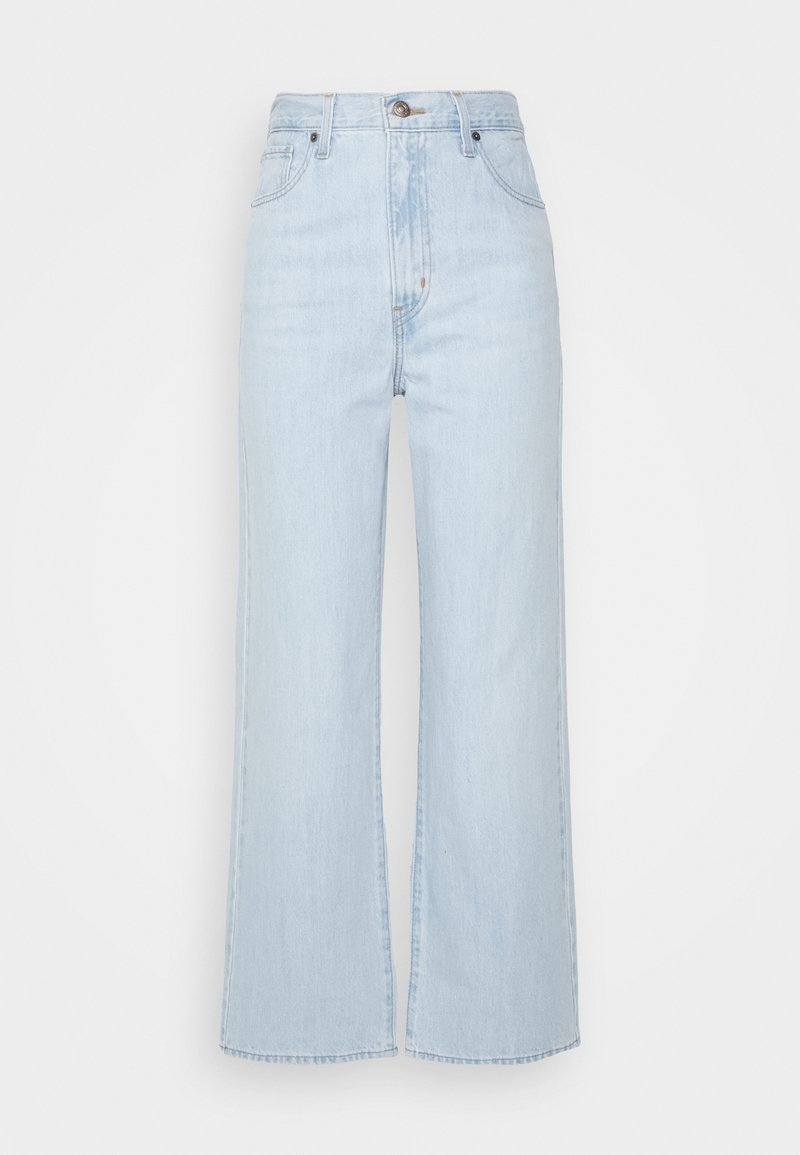 Jean bleu clair taille haute à jambes larges avec fermeture devant par boutons et zip, passants de ceinture, poches devant et derrière.
