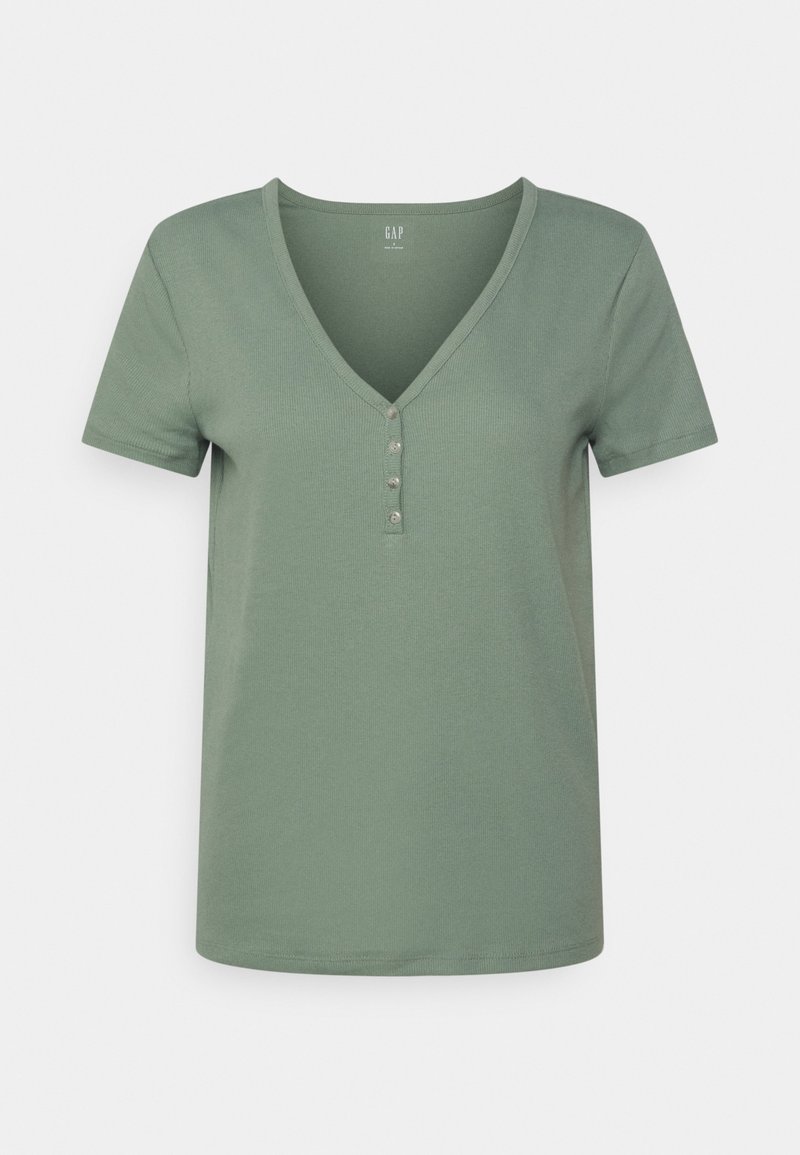 T-shirt vert sauge à manches courtes, côtelé avec un col en V et quatre petits boutons au centre devant, présenté sur un fond uni.