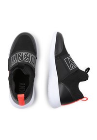 Scarpe da ginnastica nere con parte superiore in rete, cintura elastica e accento arancione sul tallone; presentano una suola in gomma bianca e una forma rotonda.