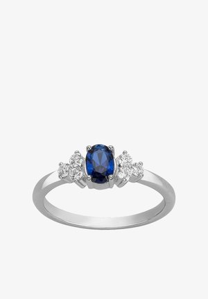 Bague en argent avec une pierre centrale ovale en saphir bleu, flanquée de trois petits diamants ronds clairs de chaque côté.