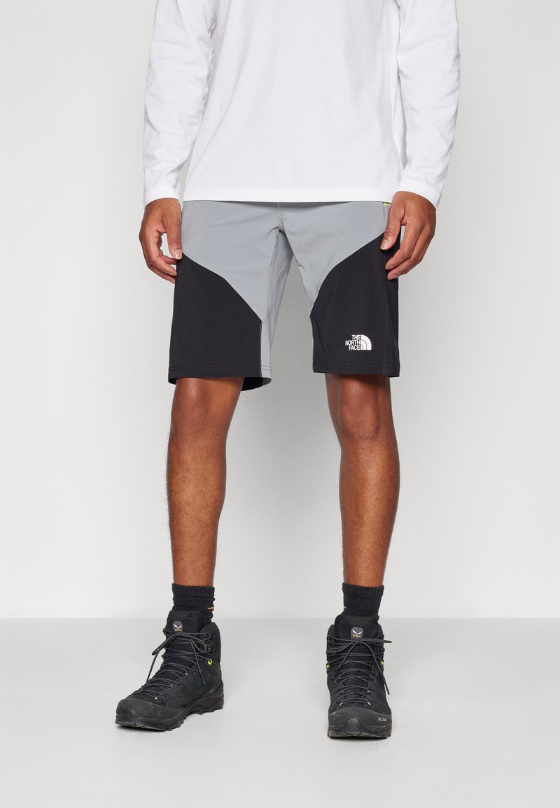 Melnas un pelēkas šortas ar ģeometrisku dizainu, izgatavotas no viegla auduma. Tām ir The North Face logo uz apakšējās kājas.