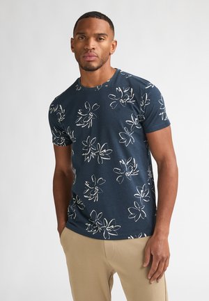 Marineblaues T-Shirt mit kurzen Ärmeln, weißen Blumenmustern, rundem Ausschnitt und weichem Stoff mit lockerem Schnitt. Minimalistisches Logodetail.