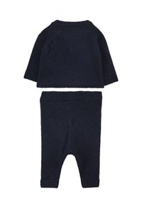 Ciemnoniebieski dzianinowy zestaw składający się z bluzki z długim rękawem i okrągłym dekoltem oraz dopasowanych spodni z prążkowanej dzianiny z elastycznym pasem.