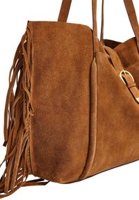 Borsa tote in suede marrone con dettagli di frange laterali, texture liscia e un accento in metallo dorato sulla tracolla.