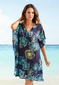 Kaftano floreale navy con grandi motivi di ibisco turchese e giallo. Tessuto leggero con vestibilità morbida e scollatura a V.