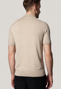 Khaki koszulka polo z krótkim rękawem, wykonana z dzianiny, z prążkowanym kołnierzykiem i mankietami. Gładki materiał o dopasowanym kroju w talii.