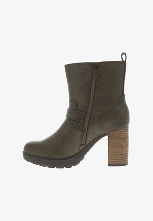 Bottine olive à la cheville avec une fermeture éclair latérale, en matériau texturé, et un talon en bois épais. Présente un détail de sangle sur le dessus.