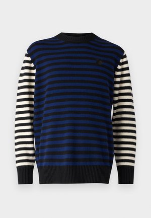 Sweter w pasiaki z poziomymi pasami w kolorze granatowym i czarnym na korpusie oraz pionowymi pasami w kolorze czarnym i białym na rękawach. Czarny ściągacz przy kołnierzyku i u dołu.