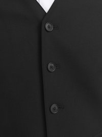Black vest featuring a textured fabric, sharp v-neckline, and three black buttons. White shirt visible beneath the vest.