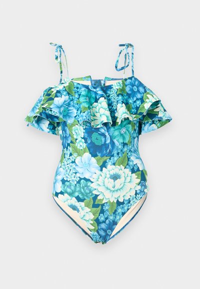 Μπλε ολόσωμο μαγιό με floral σχέδιο, με βολάν χωρίς ώμους και δεμένες τιράντες σε ουδέτερο φόντο.