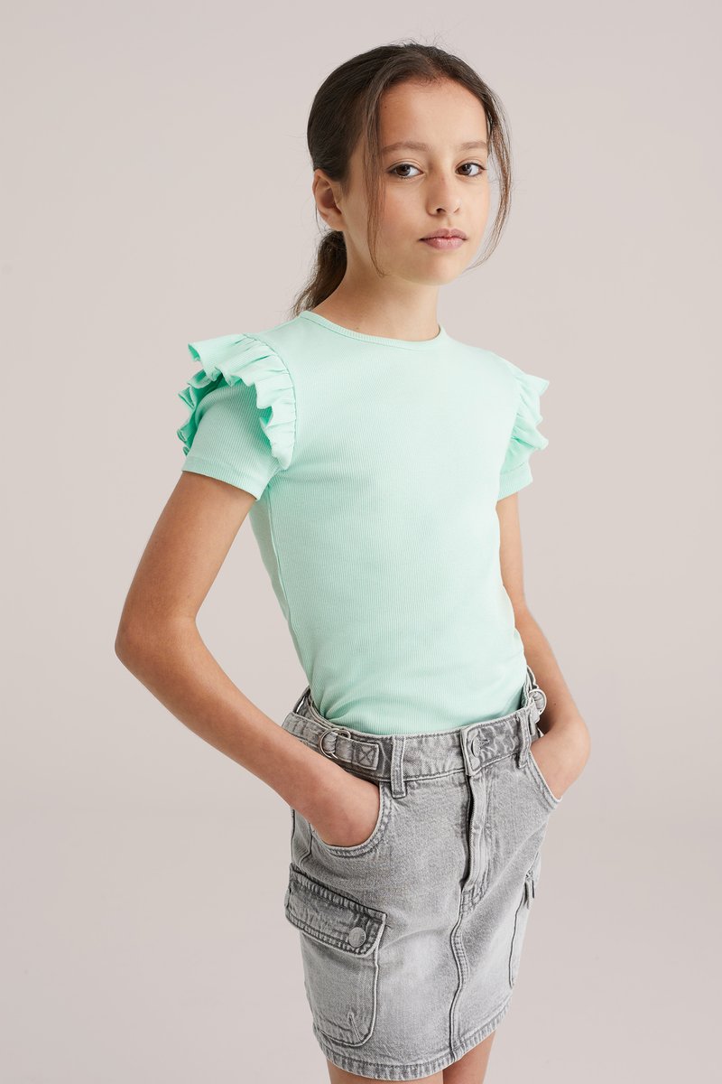 T-shirt vert menthe côtelé avec manches courtes volantées, associé à une jupe en denim gris avec poches et taille ceinturée.