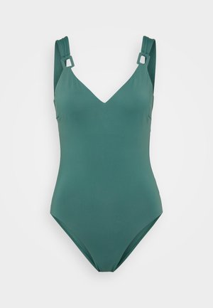 Cilvēka zila viengabala peldkostīms ar V veida kakla izgriezumu, platām siksnām un kvadrātveida aksesuāriem. Gluda, elastīga materiāla un plūstošs dizains.