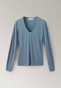 Haut en maille bleu à manches longues et col en V, posé à plat sur un fond clair avec un design simple et ajusté.