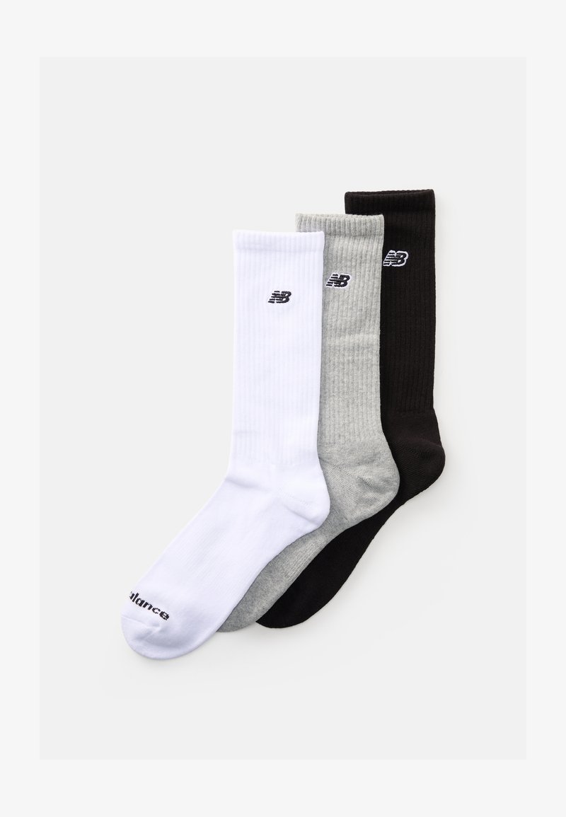 Tri para nove New Balance čarape u bijeloj, sivoj i crnoj boji, svaka s logotipom brenda blizu gornjeg ruba, raspoređene preklopljene.