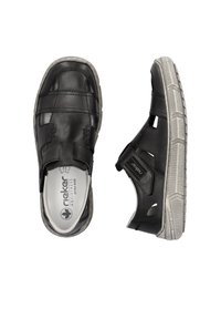 Schwarze Leder-Schlupfschuhe mit ausgeschnittenen Abschnitten und grauer Gummisohle. Mit gepolsterten Innensohlen und strukturiertem Stich für zusätzlichen Halt.
