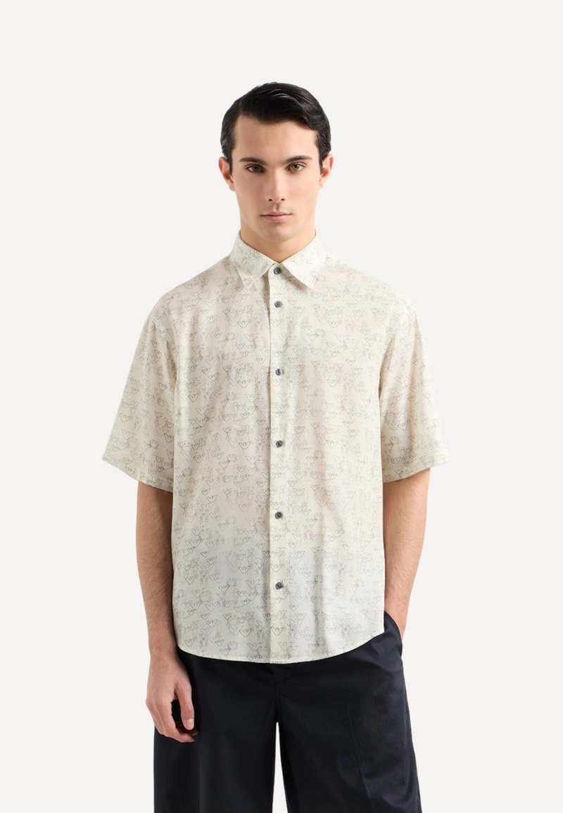 Camicia a maniche corte in tessuto leggero, con base crema e un sottile motivo di contorni scuri, dotata di chiusura con bottoni.