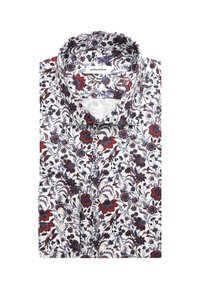 Chemise blanche pliée avec motif floral rouge, bleu et marron et boutons blancs, avec un col classique et une étiquette de marque visible.