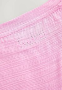 Lichtroze sportshirt met een gestructureerde stof, ronde halslijn en een klein reliëf "ACTIVE" logo op de achterkant.