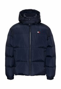 Marinblå puffer-jacka med dragkedja fram, justerbar huva och ribbade manschetter. Har horisontella kviltade sektioner och en liten logo på bröstet.