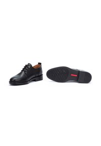 Black leather dress shoes with a smooth surface, rounded toe, lace-up design, and textured rubber sole featuring a red accent.