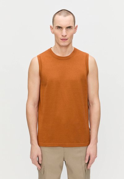 Haut sans manches marron en tissu tricoté, avec un col rond et une coupe décontractée, associé à un pantalon cargo beige clair.
