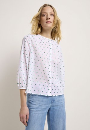 Weiße Bluse mit grünen gepunkteten Mustern, runder Ausschnitt, durchgehende Knopfleiste und 3/4-lange Puffärmel. Leichter Stoff, weiche Textur, lockere Passform.