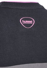 Zwarte sweatshirt met een ronde hals, een roze kraagaccent en een opvallend roze Hummel-logo op de achterkant. Soepele textuur met een moderne pasvorm.