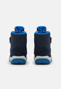 Zapatillas altas de color azul marino con un tejido texturizado y detalles de ante, con un forro de felpa azul y una suela de goma blanca.