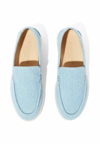 Svijetloplave slip-on cipele od tkanine nalik na traper, s glatkom površinom, zaobljenim vrhom i bijelim gumiranim potplatom. Jednostavne šavove kao ukras.