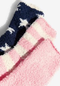 Három pár bolyhos zokni: sötétkék, fehér csillagokkal, pink és fehér csíkos, valamint egyszínű pink. Mindegyik zokni puha tapintású és plüss anyagú.