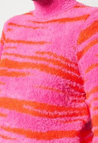 Maglione a maglia morbida con strisce rosa brillante e arancione, collo alto e tessuto morbido. Ideale per vestirsi in clima freddo.