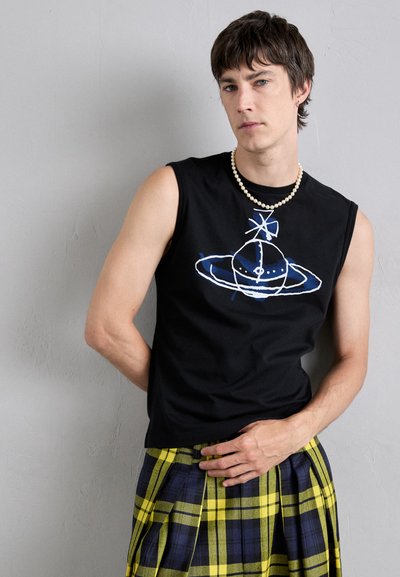 Schwarzes ärmelloses Shirt mit einem blauen und weißen grafischen Design. Kombiniert mit einem plissierten gelben und marineblauen Karokilt. Akzentuiert mit einer Perlenkette.