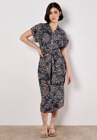 Vestido azul marino de botones con un patrón de hojas de palma en beige, ceñido a la cintura, con mangas cortas y un diseño hasta la rodilla.