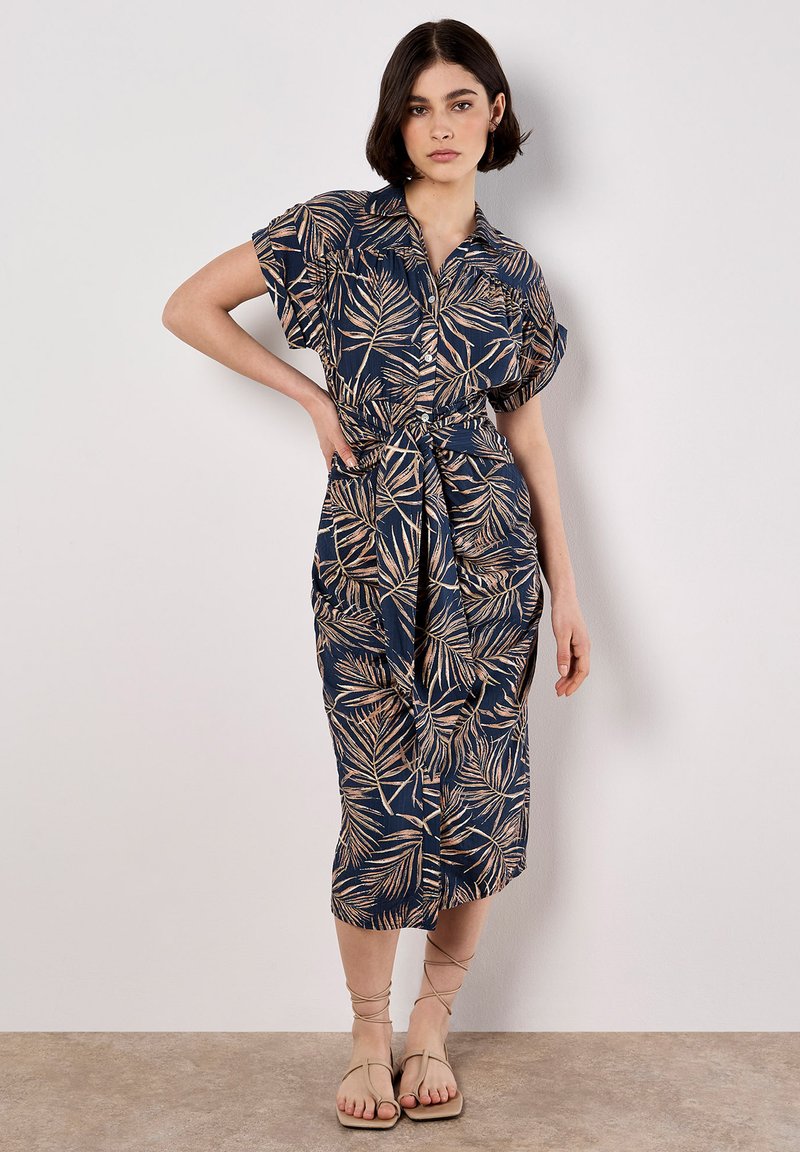 Vestido azul marino de botones con un patrón de hojas de palma en beige, ceñido a la cintura, con mangas cortas y un diseño hasta la rodilla.