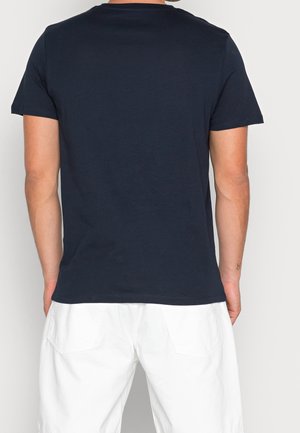 Marineblaue T-Shirt mit kurzen Ärmeln und klassischem Rundhalsausschnitt. Hergestellt aus weichem Baumwollstoff, verfügt über eine normale Passform und ein minimalistisches Design.