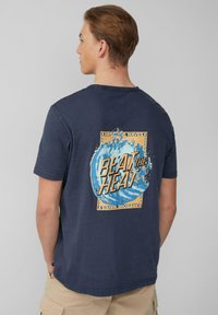 Marineblauwe katoenen t-shirt met een grote grafische afbeelding op de achterkant: blauwe golven met de tekst "BEAT THE HEAT" in dikke, oranje letters.