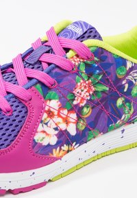 Baskets de sport violettes avec motif floral, accents roses, empeigne en mesh et intérieur vert. Elles présentent des lacets vifs et une semelle texturée.