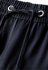 Pantaloni corti con coulisse di un blu navy scuro, dotati di una vita elastica, caratterizzati da un occhio di bue argentato per la coulisse e un tessuto testurizzato.
